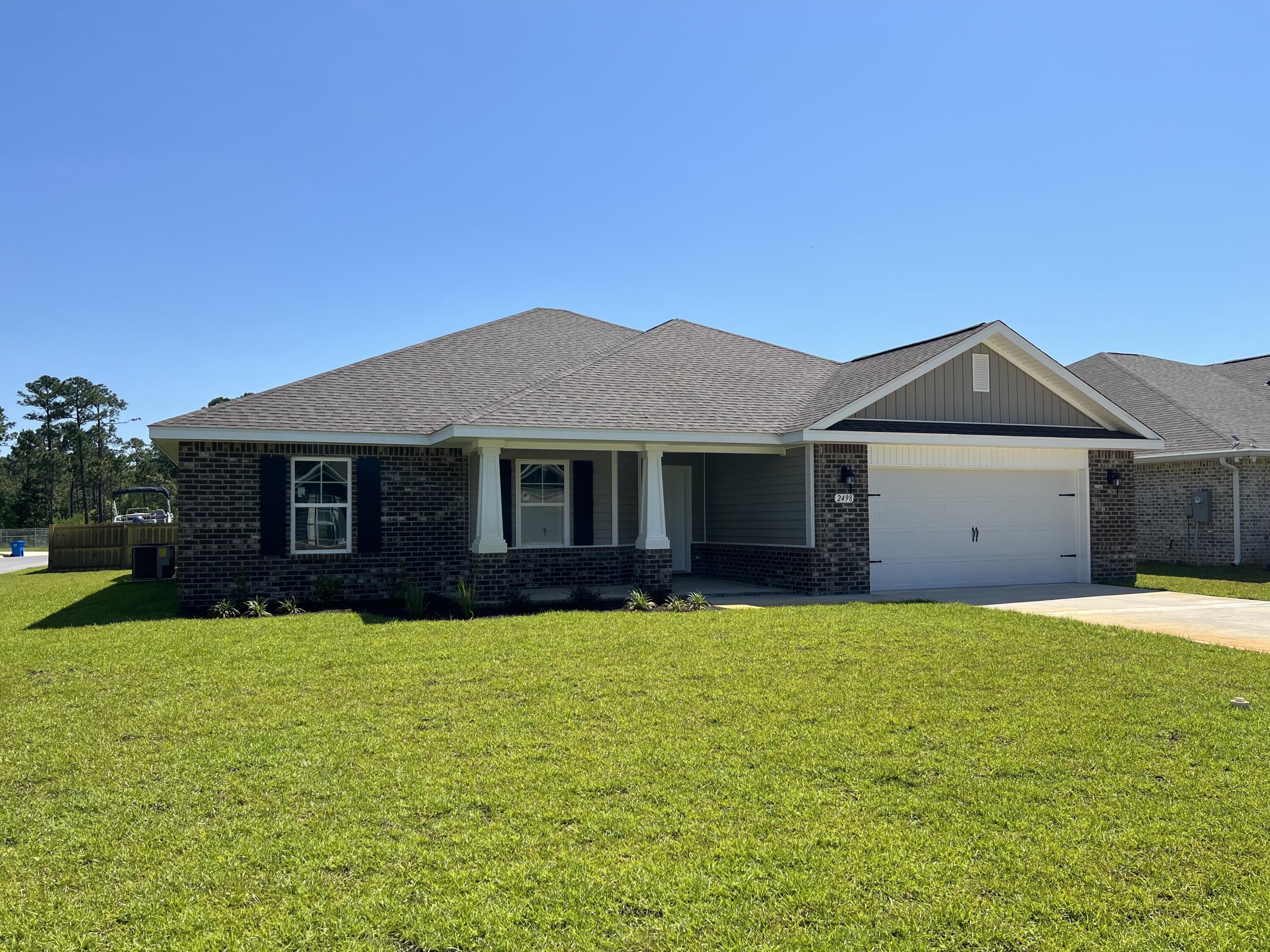 a front view of a house with yard and garage