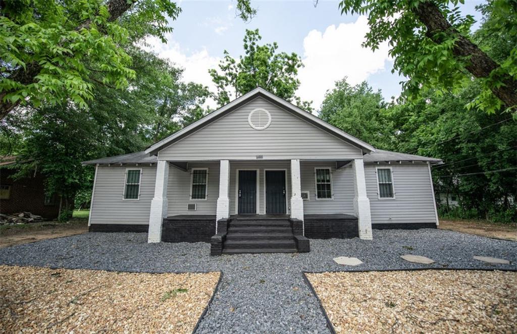 a front view of house with yard and trees in the background