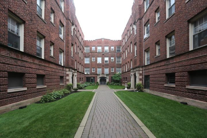 a view of a brick building next to a big yard