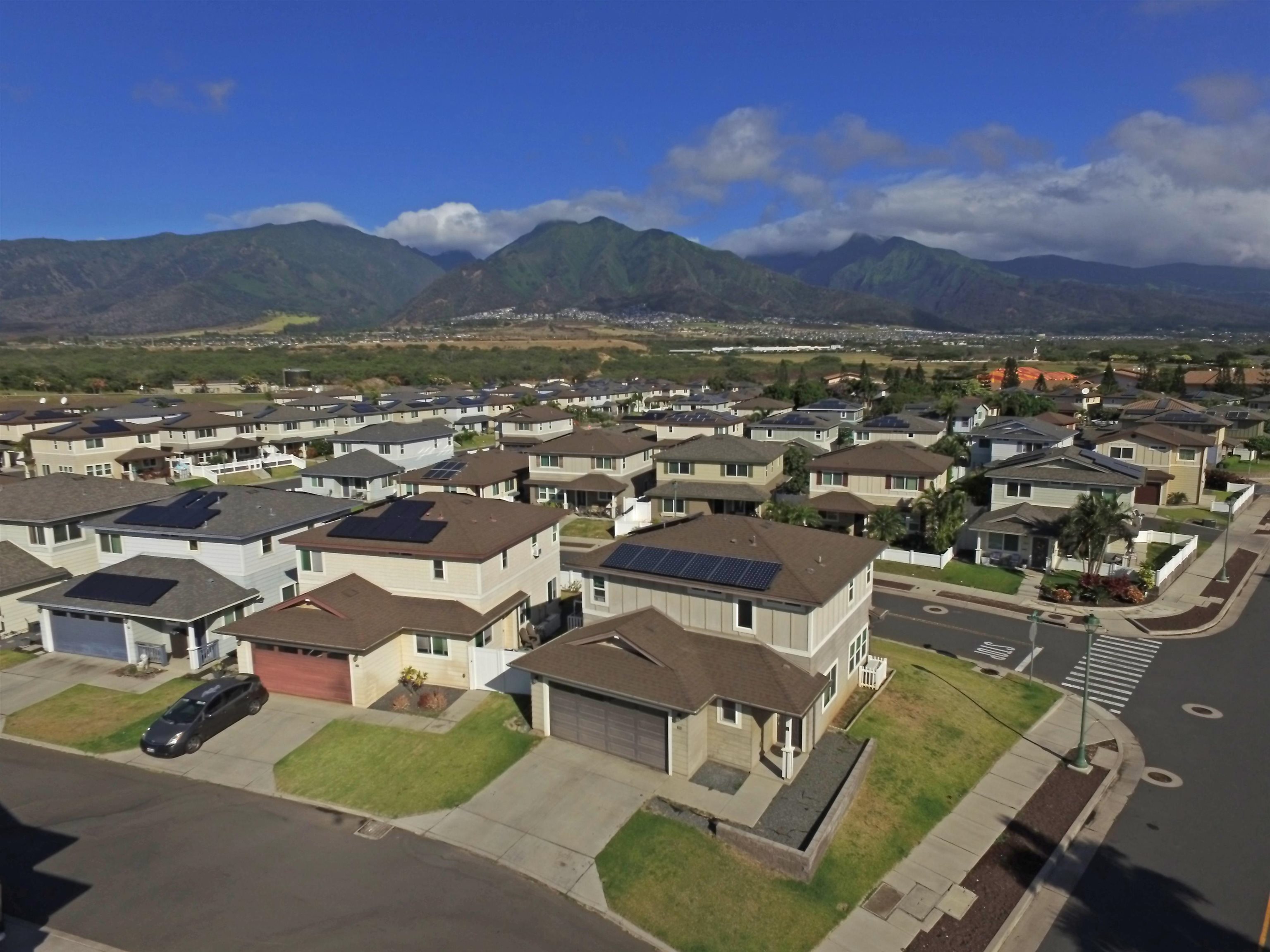 an aerial view of residential houses with outdoor space and trees