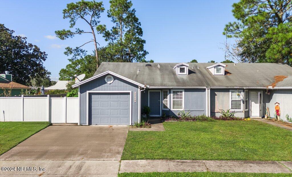 a front view of a house with a garden and trees