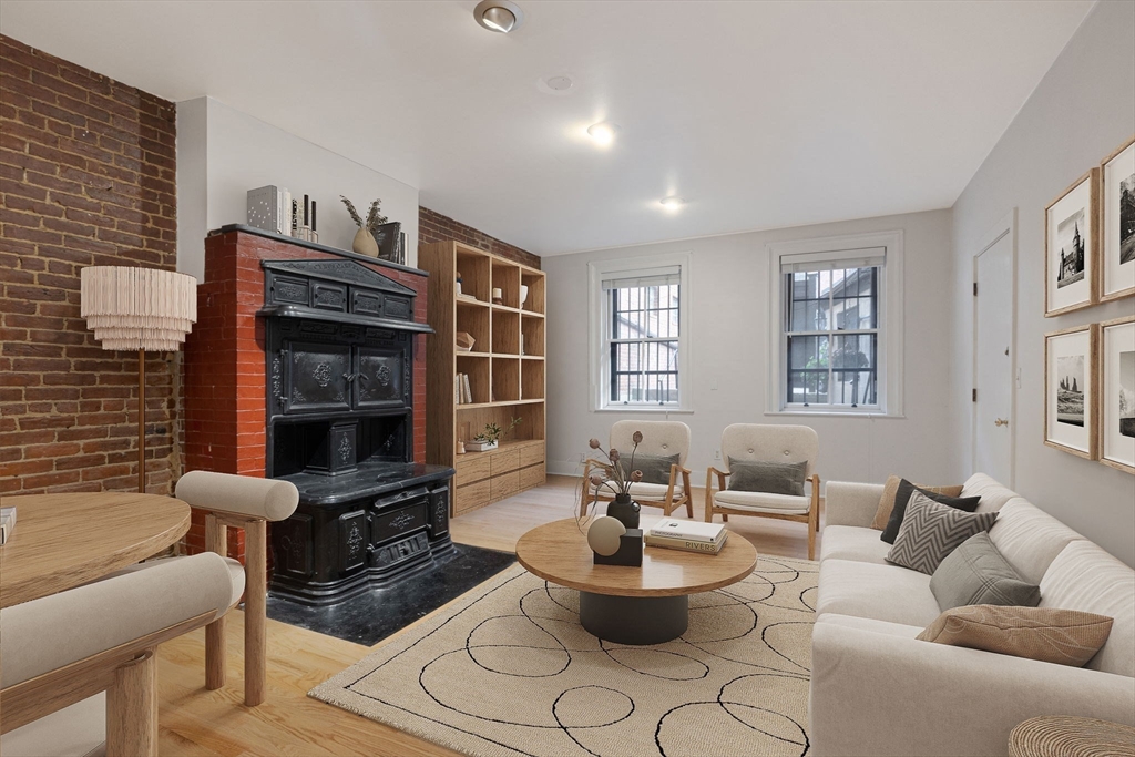 a living room with furniture a fireplace and a window