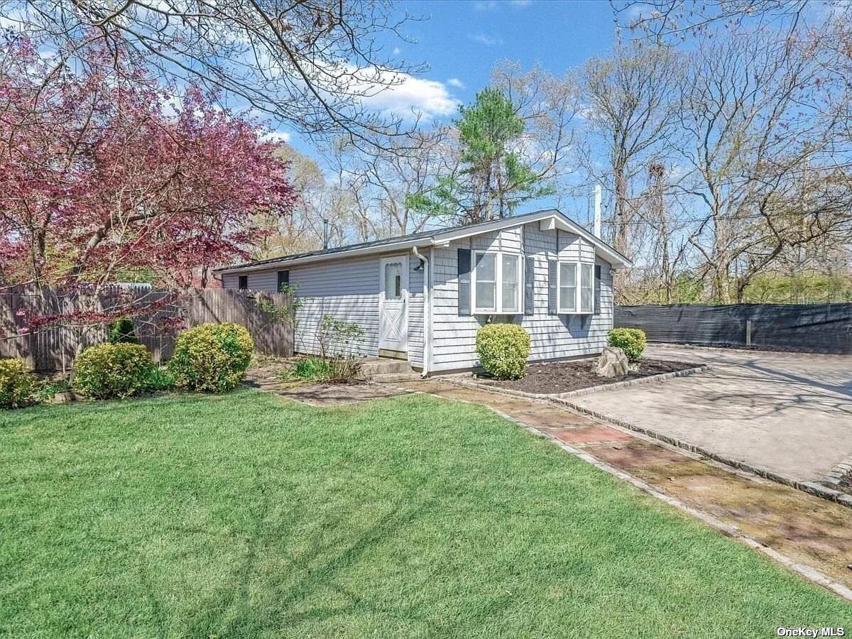 a front view of a house with yard and green space