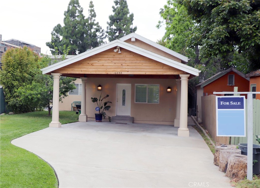 a view of a house with a patio and a yard