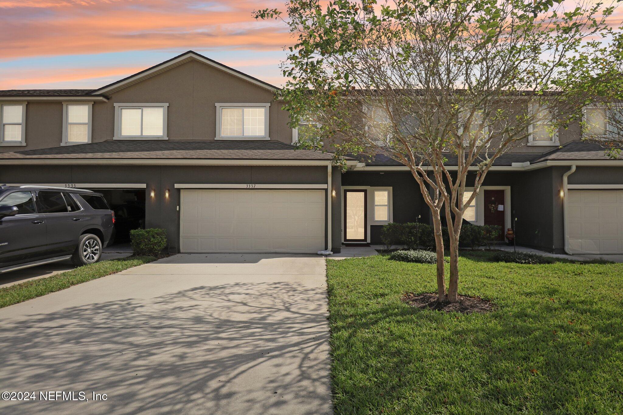 a front view of a house with a yard and garage