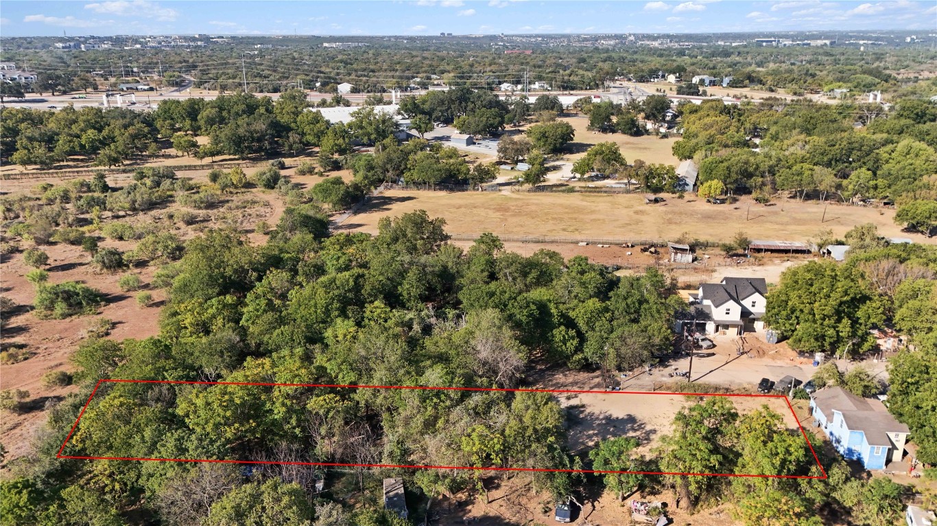 an aerial view of residential houses with outdoor space and trees