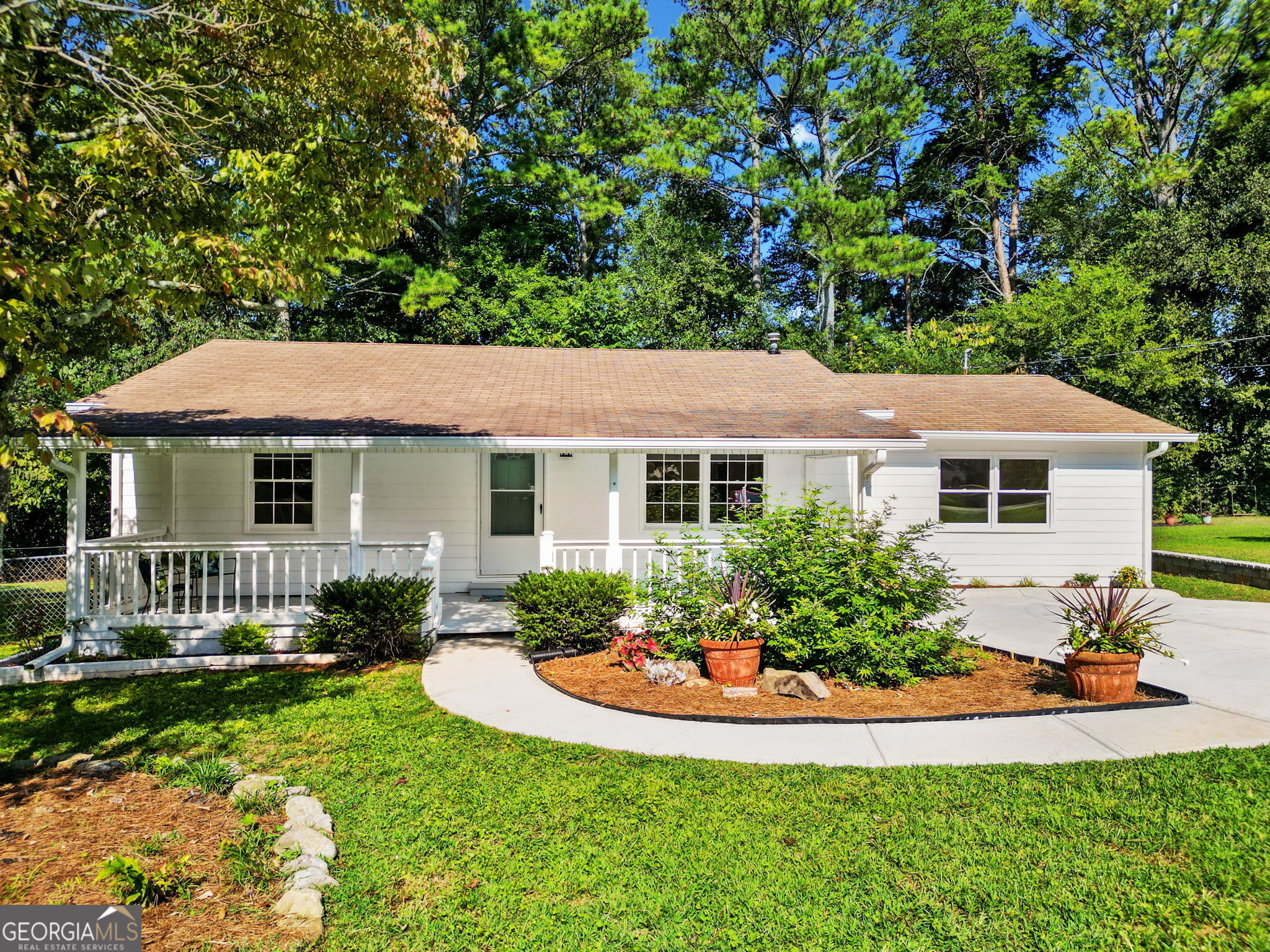 a view of house with garden and tall trees