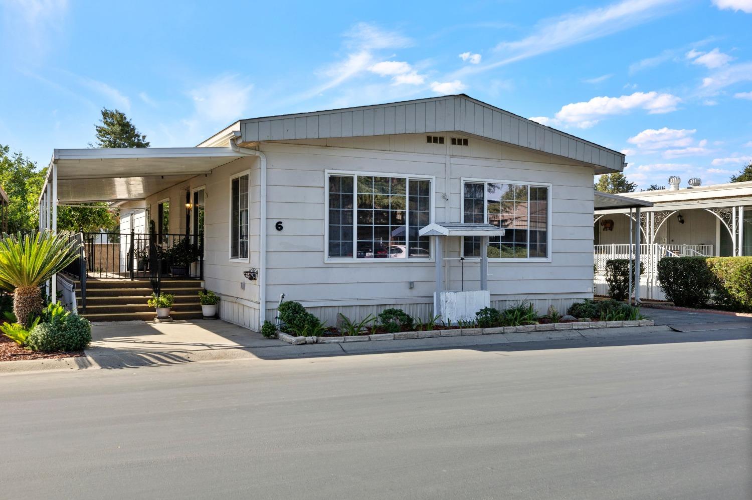 a front view of a house with a yard and outdoor seating