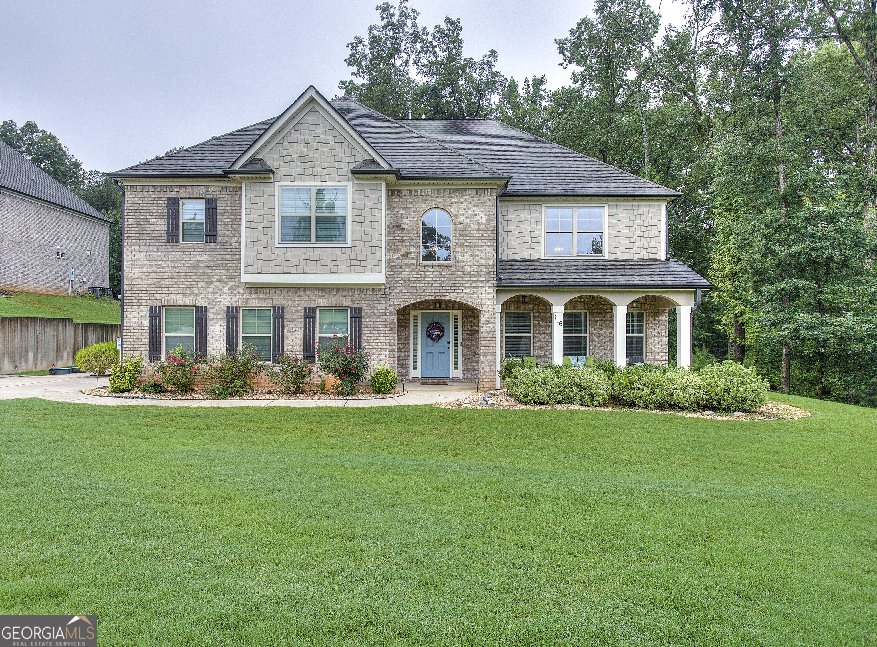 a front view of a house with a garden and porch