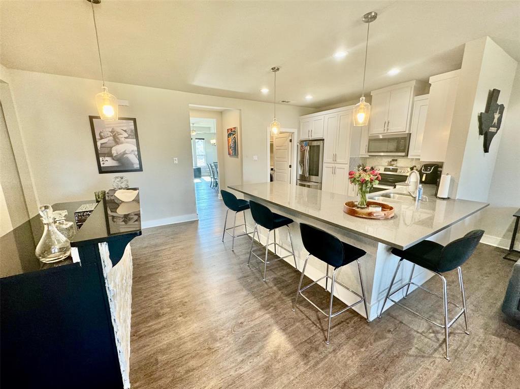 a large white kitchen with a dining table chairs and couches