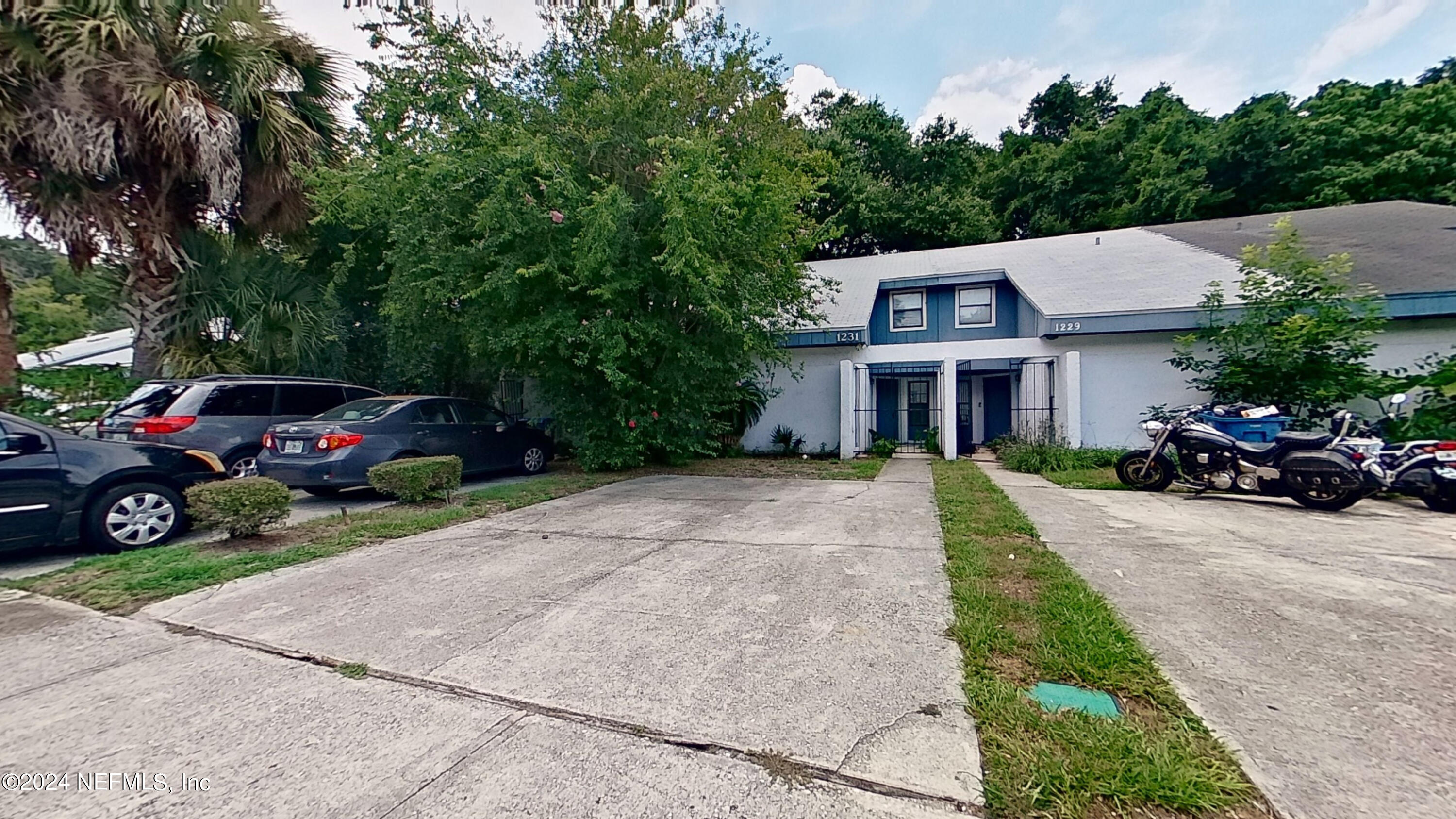 a house with car parked on the side of the road