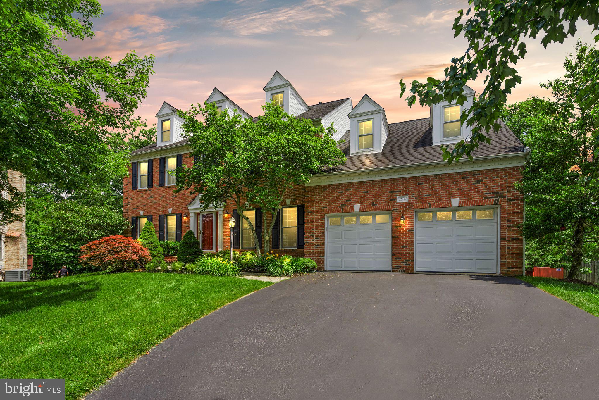 front view of a house with a yard and trees