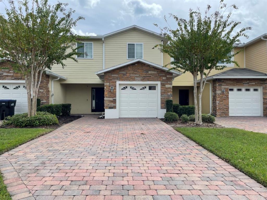 a front view of a house with a yard and a garage