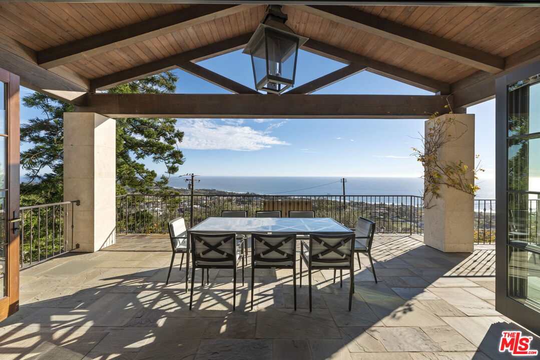 a view of a patio with a table and chairs under an umbrella