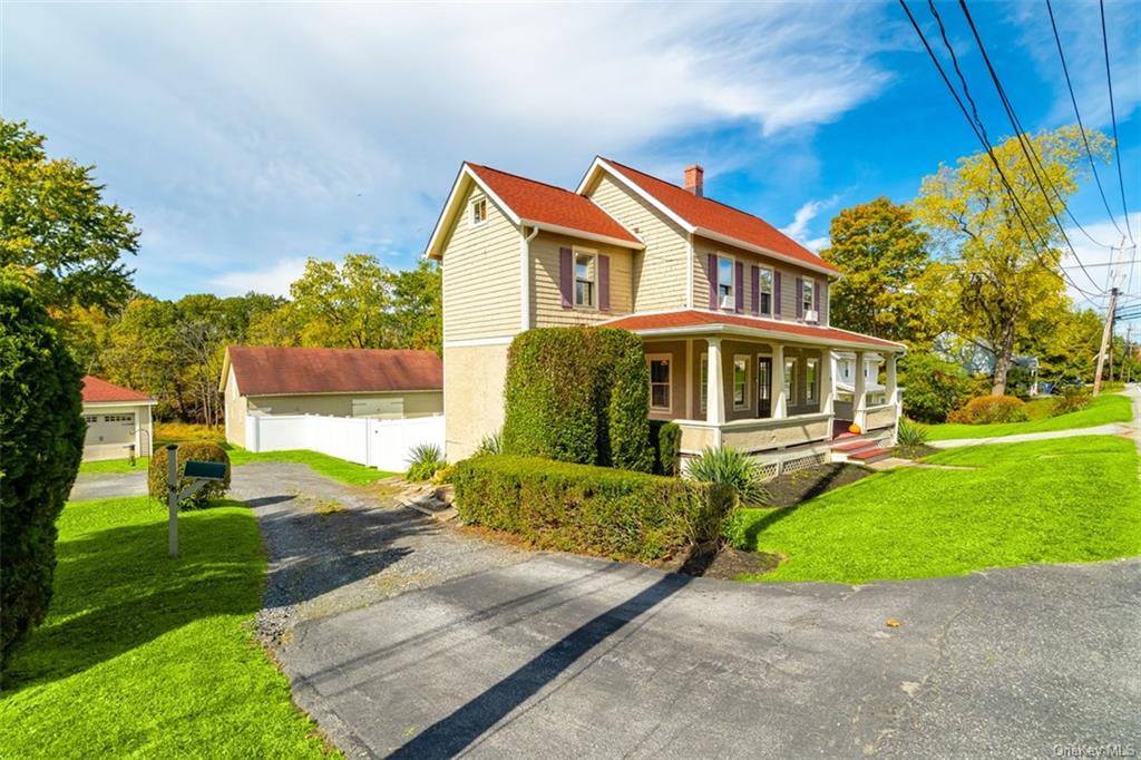 View of property exterior with a porch and a yard