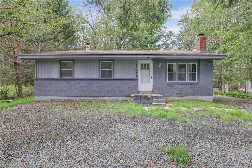 a front view of house with yard and trees