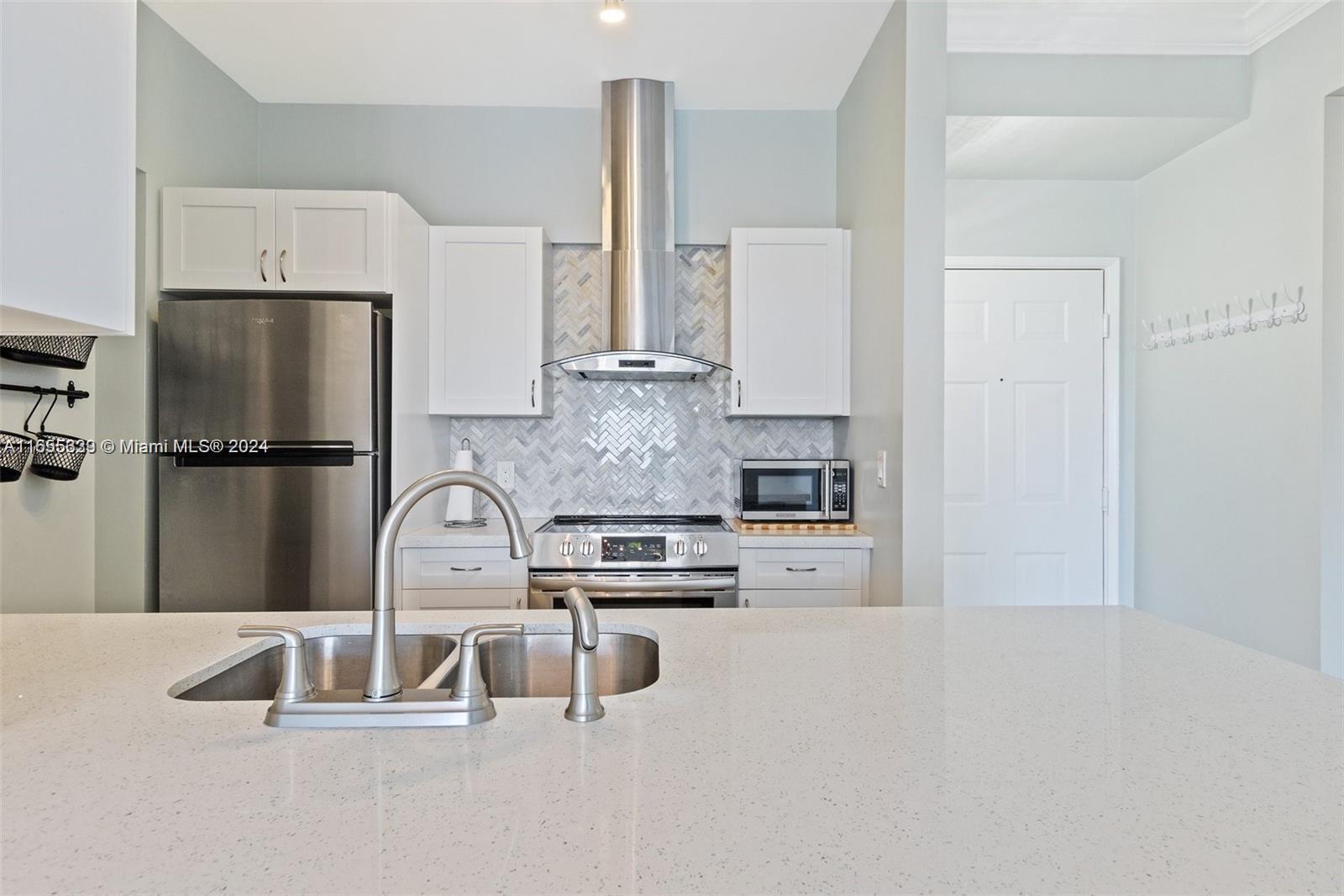 a kitchen with stainless steel appliances granite countertop a refrigerator and a sink