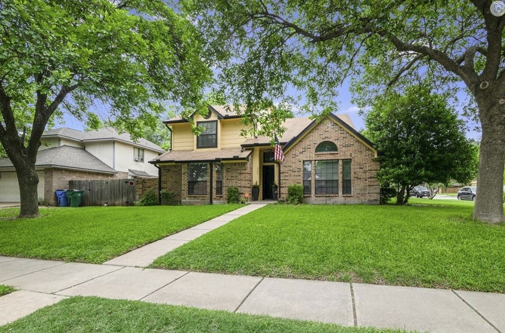 a front view of a house with a yard and trees