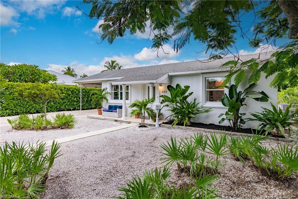 a front view of a house with a yard and a garden