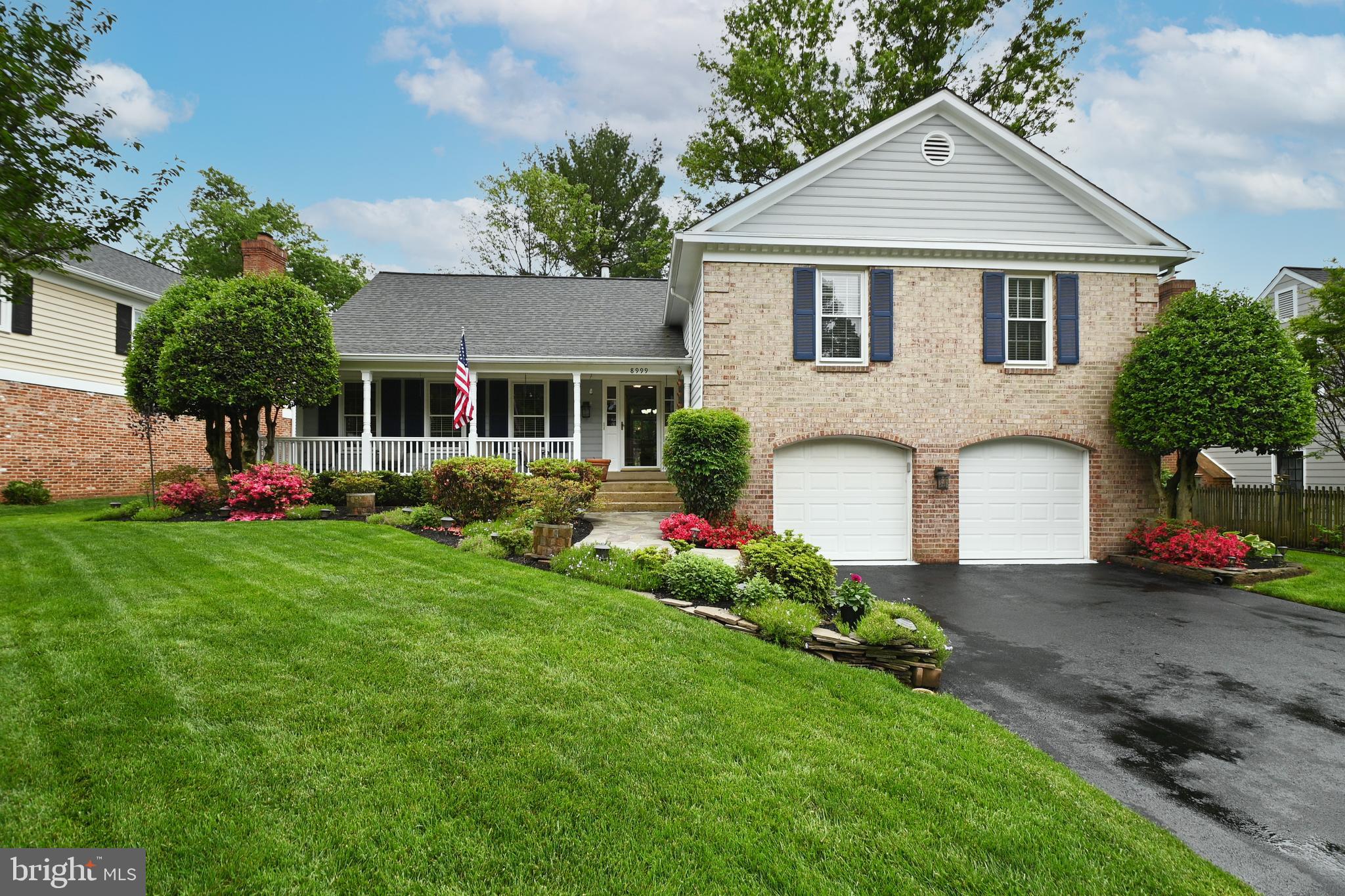 a front view of a house with a yard and trees