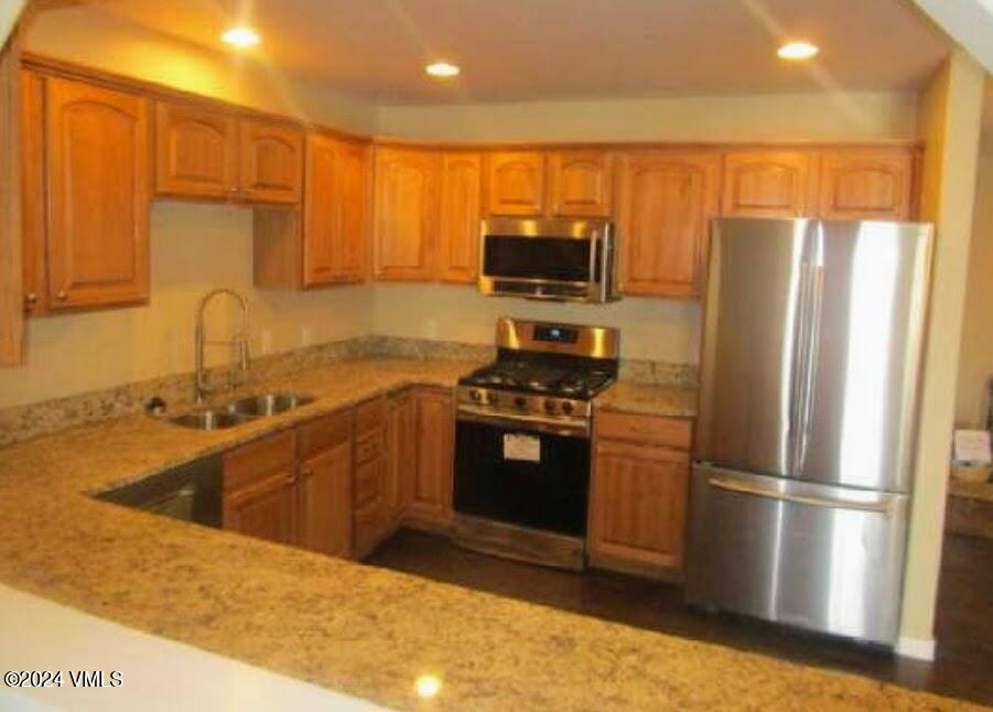 a kitchen with stainless steel appliances a refrigerator stove microwave and sink