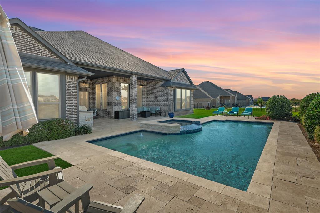 a view of swimming pool with lawn chairs and plants