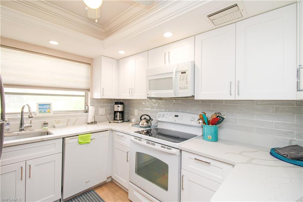 a kitchen with stainless steel appliances white cabinets sink and stove