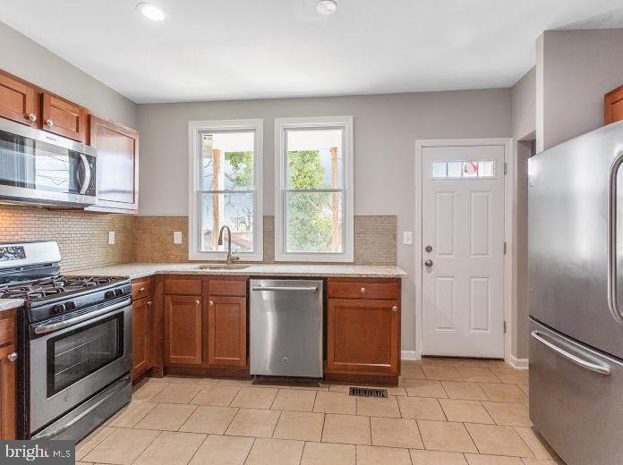 a kitchen with stainless steel appliances granite countertop a refrigerator and a sink