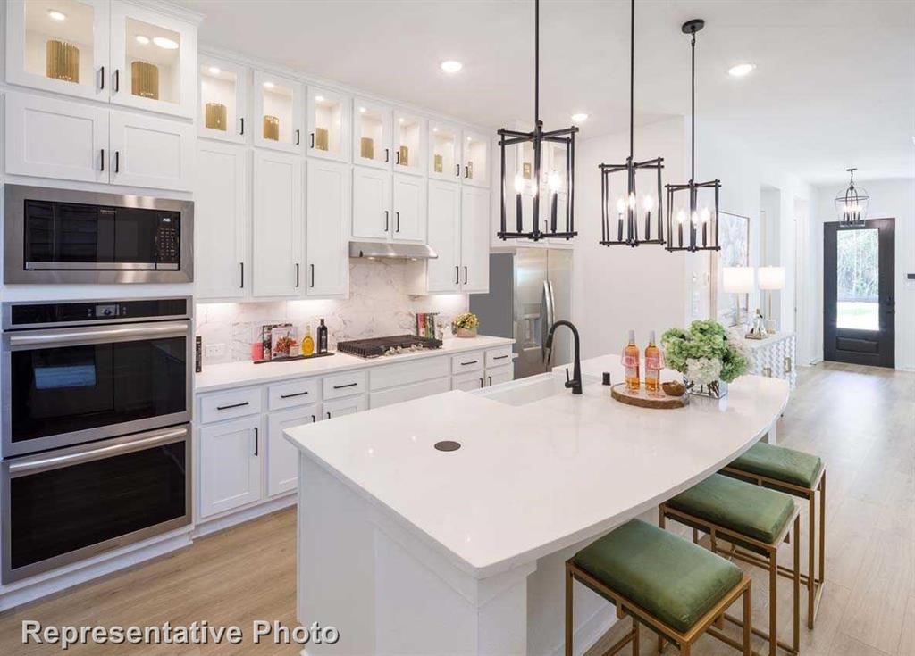 a kitchen with kitchen island a white counter top space appliances and cabinets