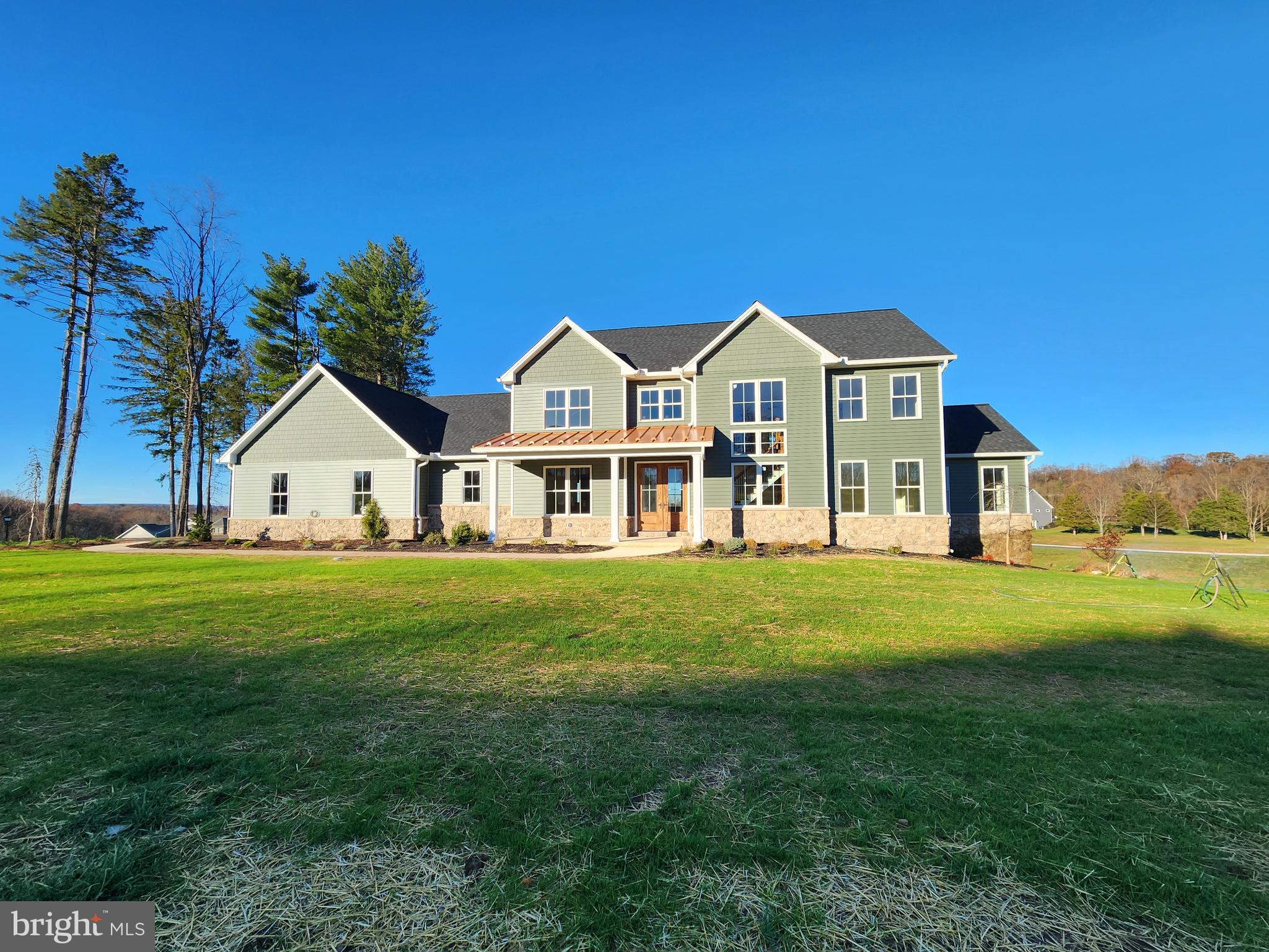 a view of a house with a big yard and large trees