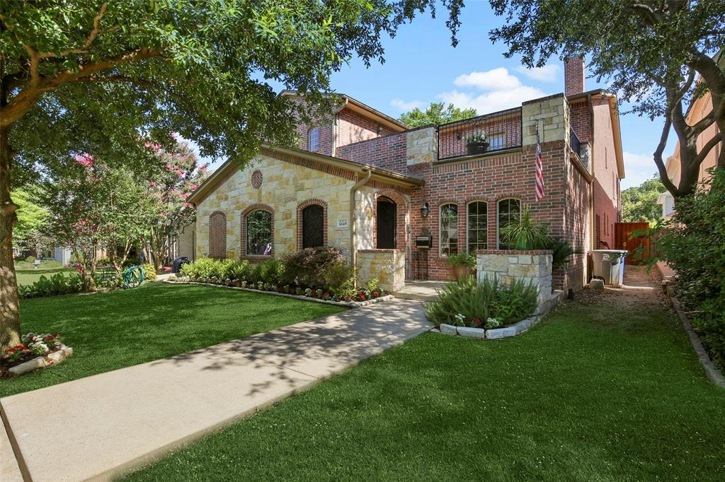 a front view of a house with a yard and potted plants