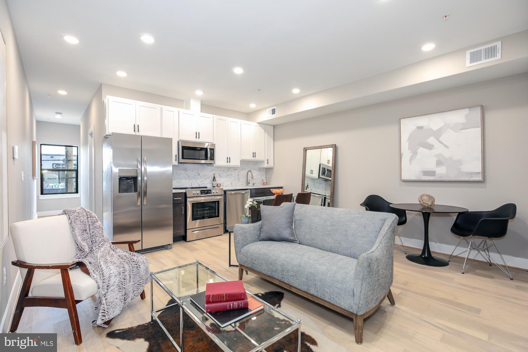 a living room with furniture kitchen and a table