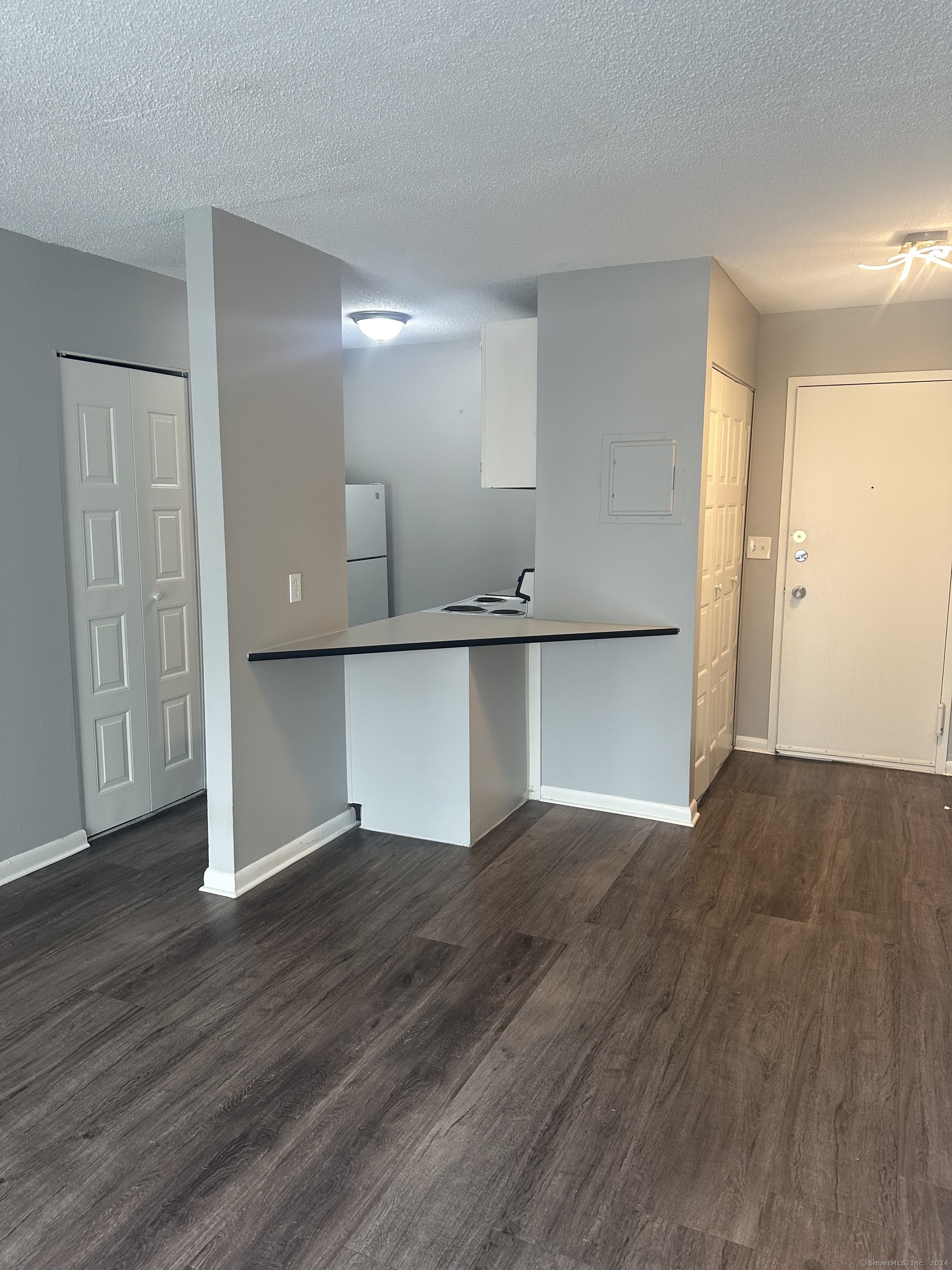 wooden floor in an empty room with a kitchen