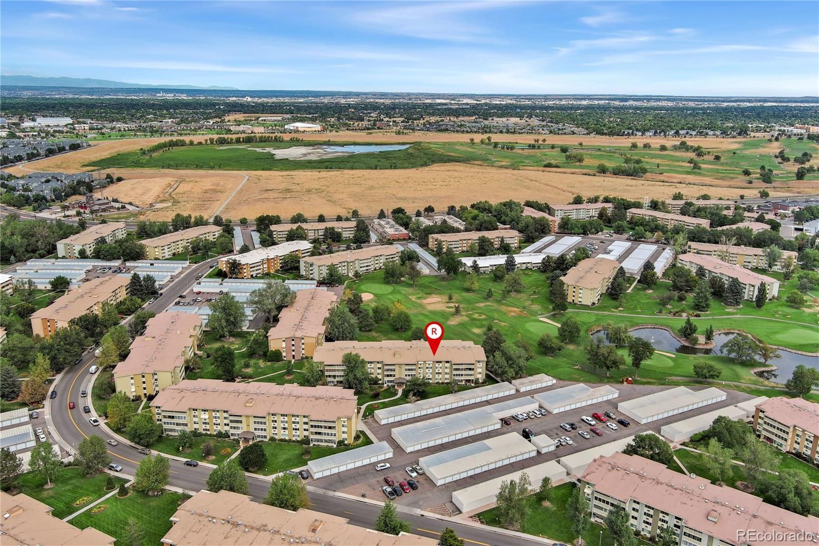 an aerial view of a city with lots of residential buildings ocean and mountain view in back