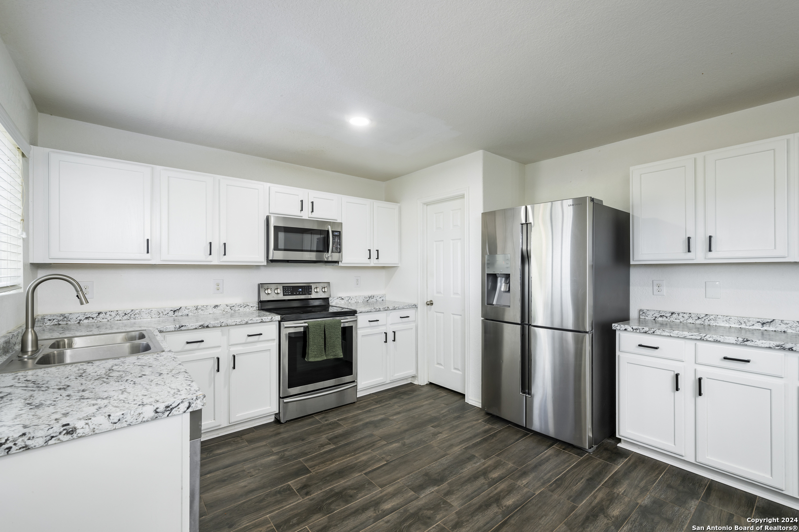 a kitchen with a refrigerator stove and sink