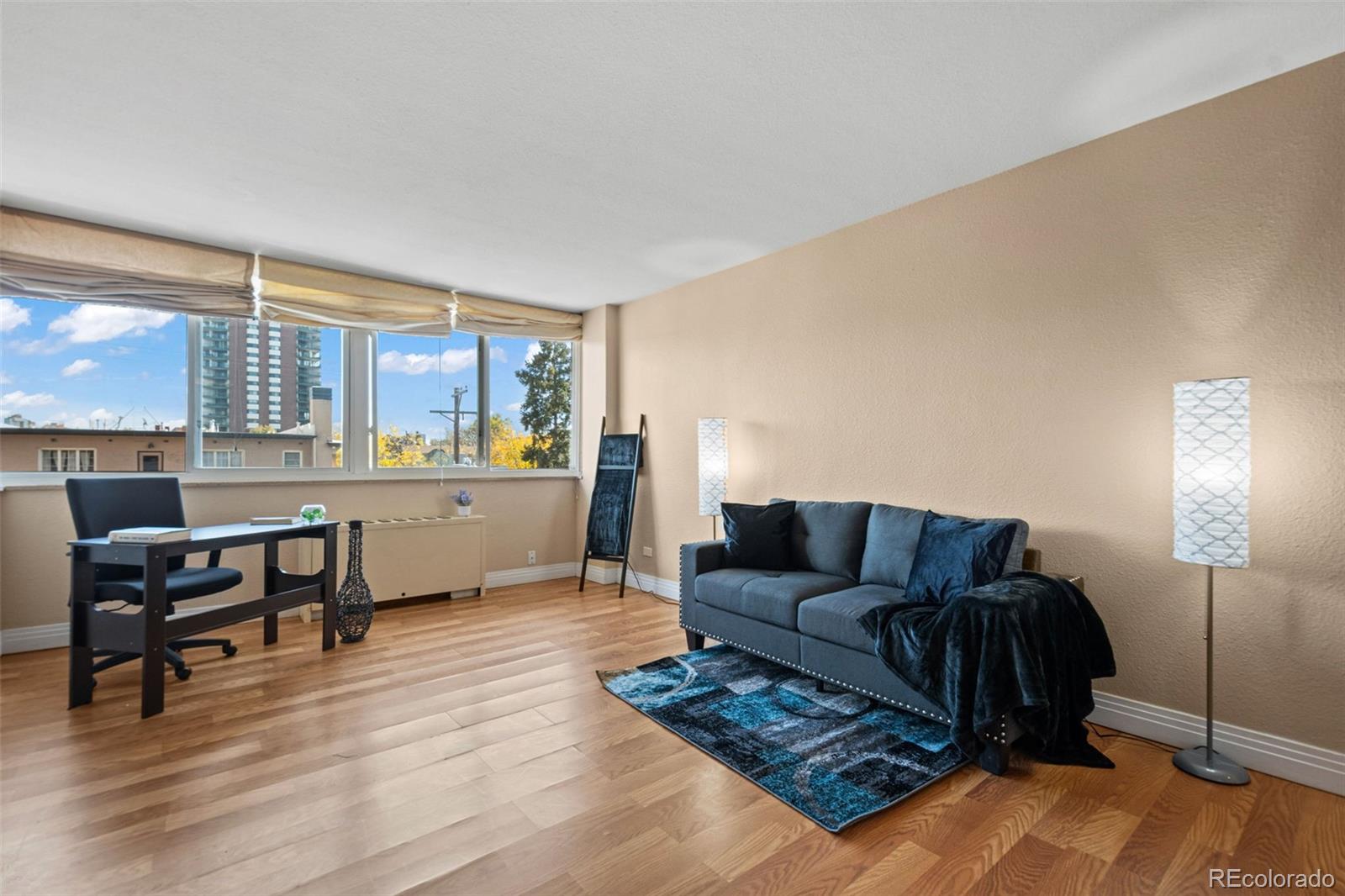 a living room with furniture and a dining table with wooden floor