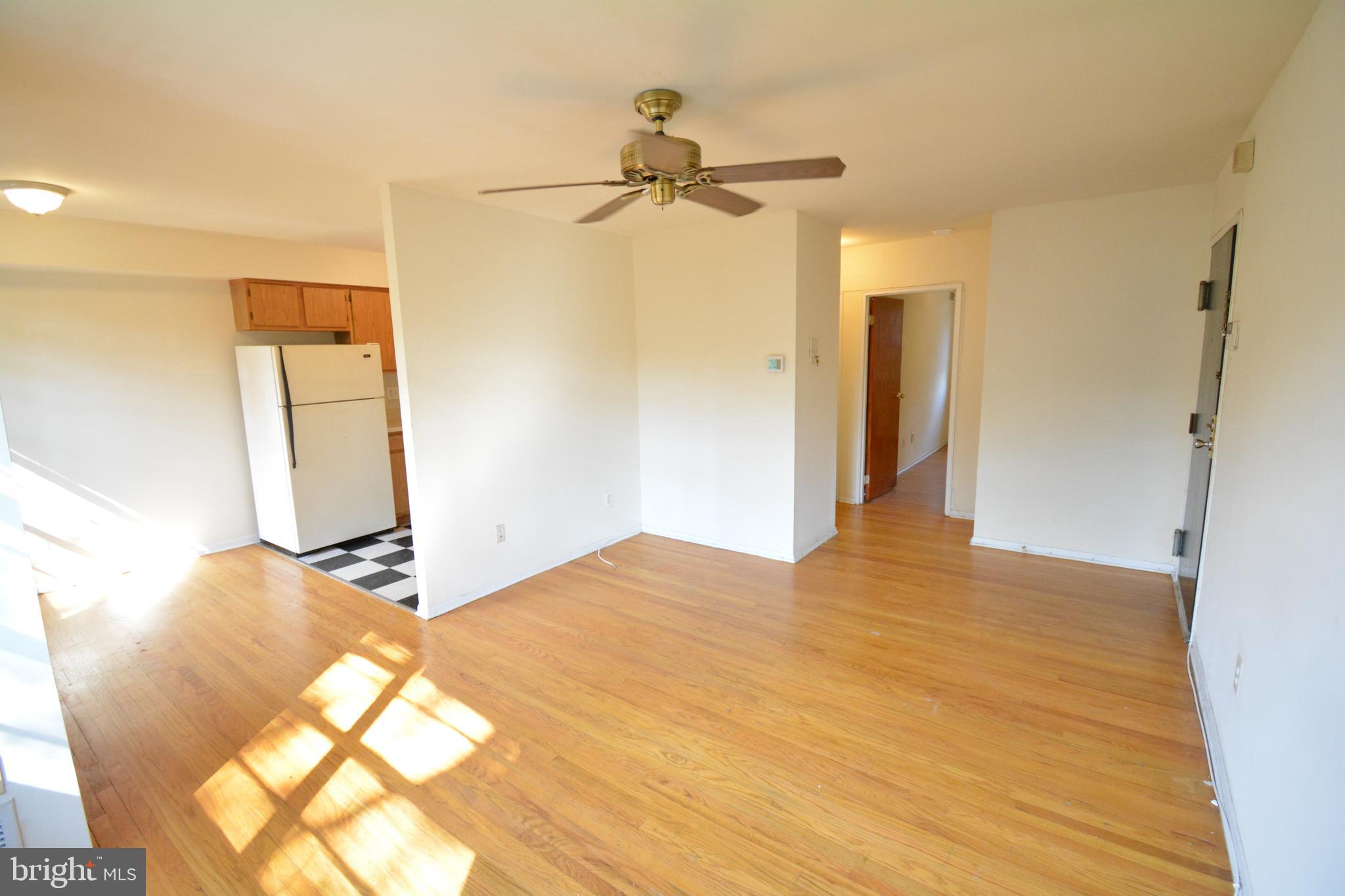 a view of a bedroom with wooden floor and a ceiling fan