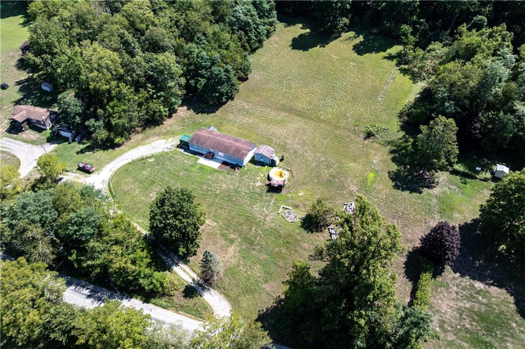 an aerial view of a house with a yard and large trees