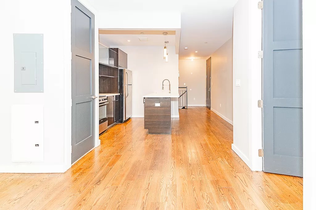 a view of a kitchen with a sink and a refrigerator