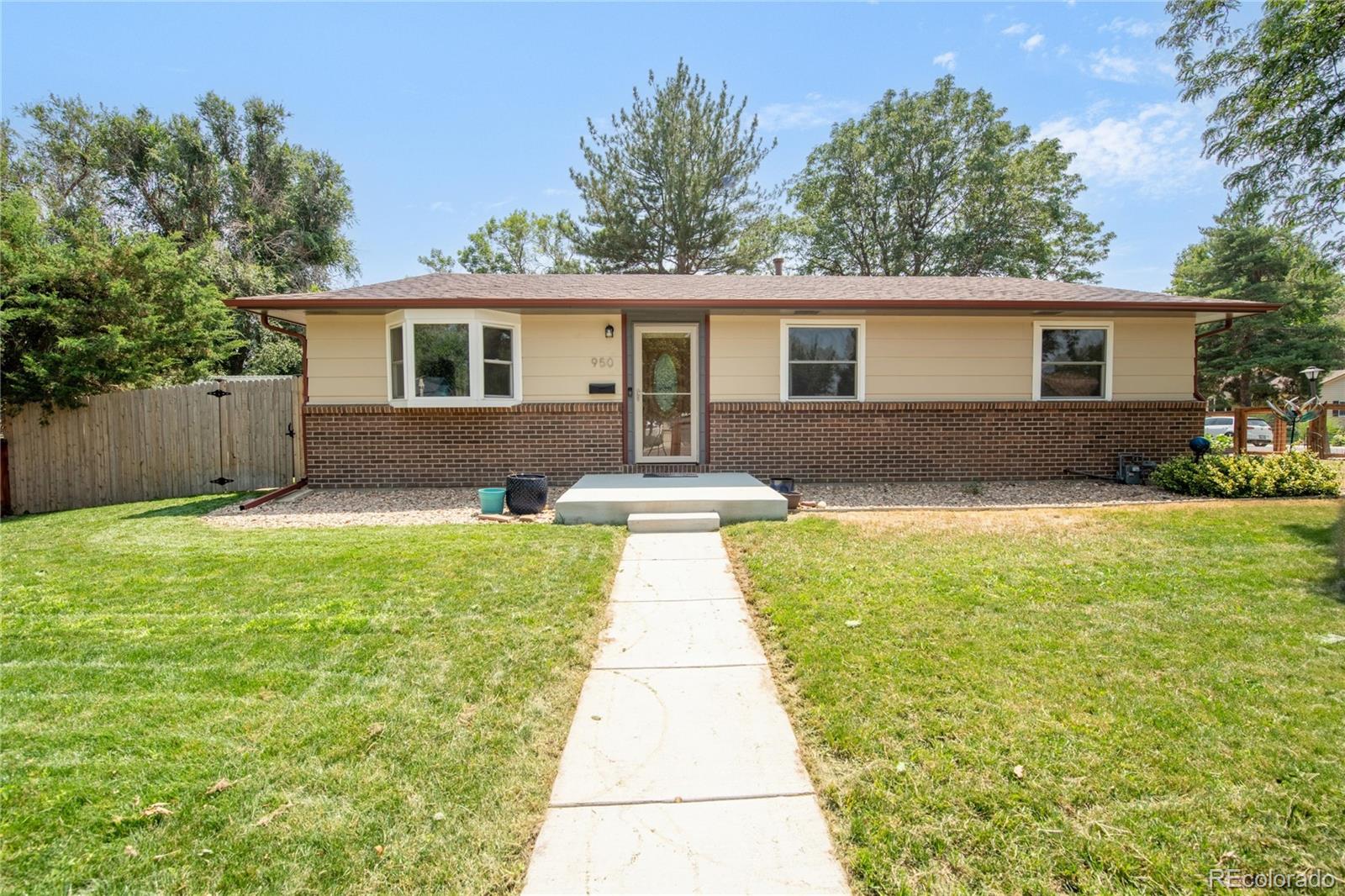 a front view of a house with a yard and trees