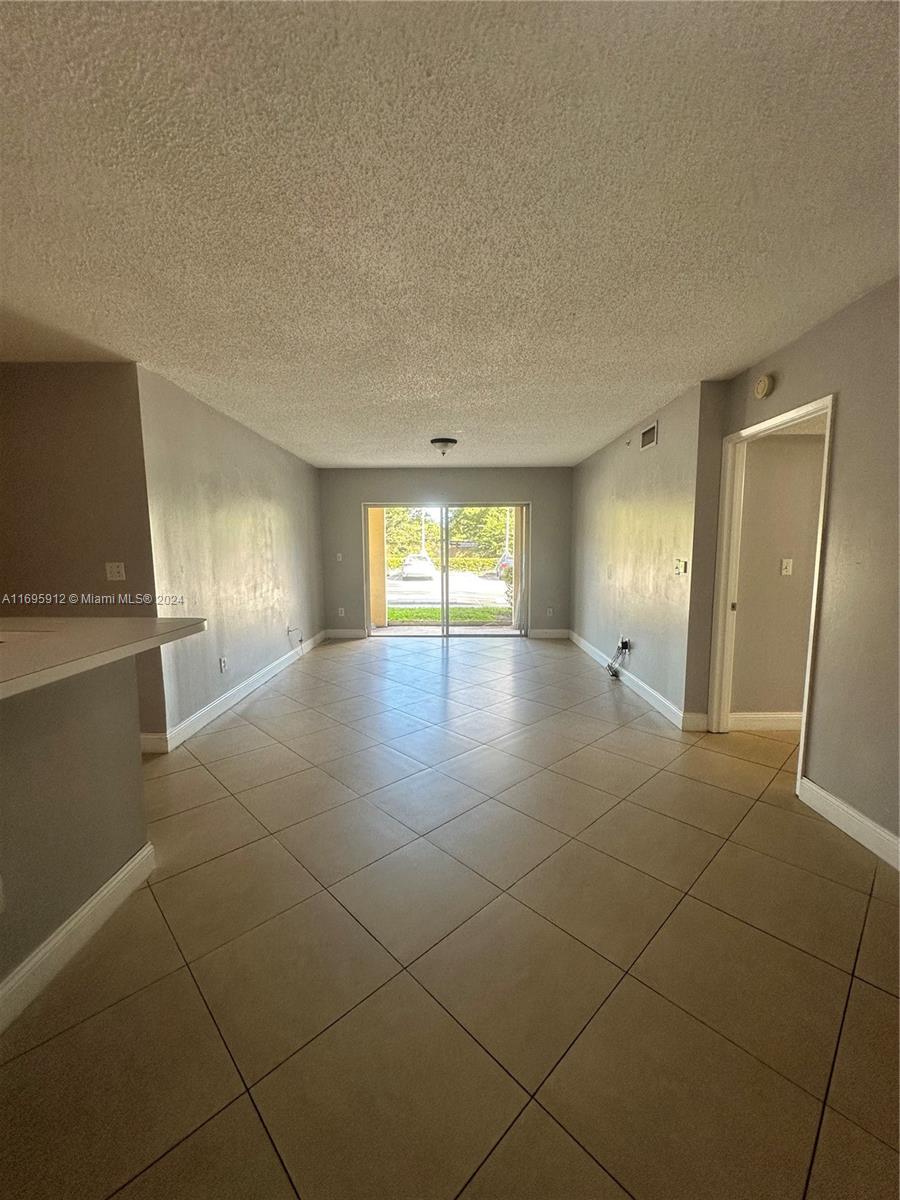 a view of an empty room with window and bathroom