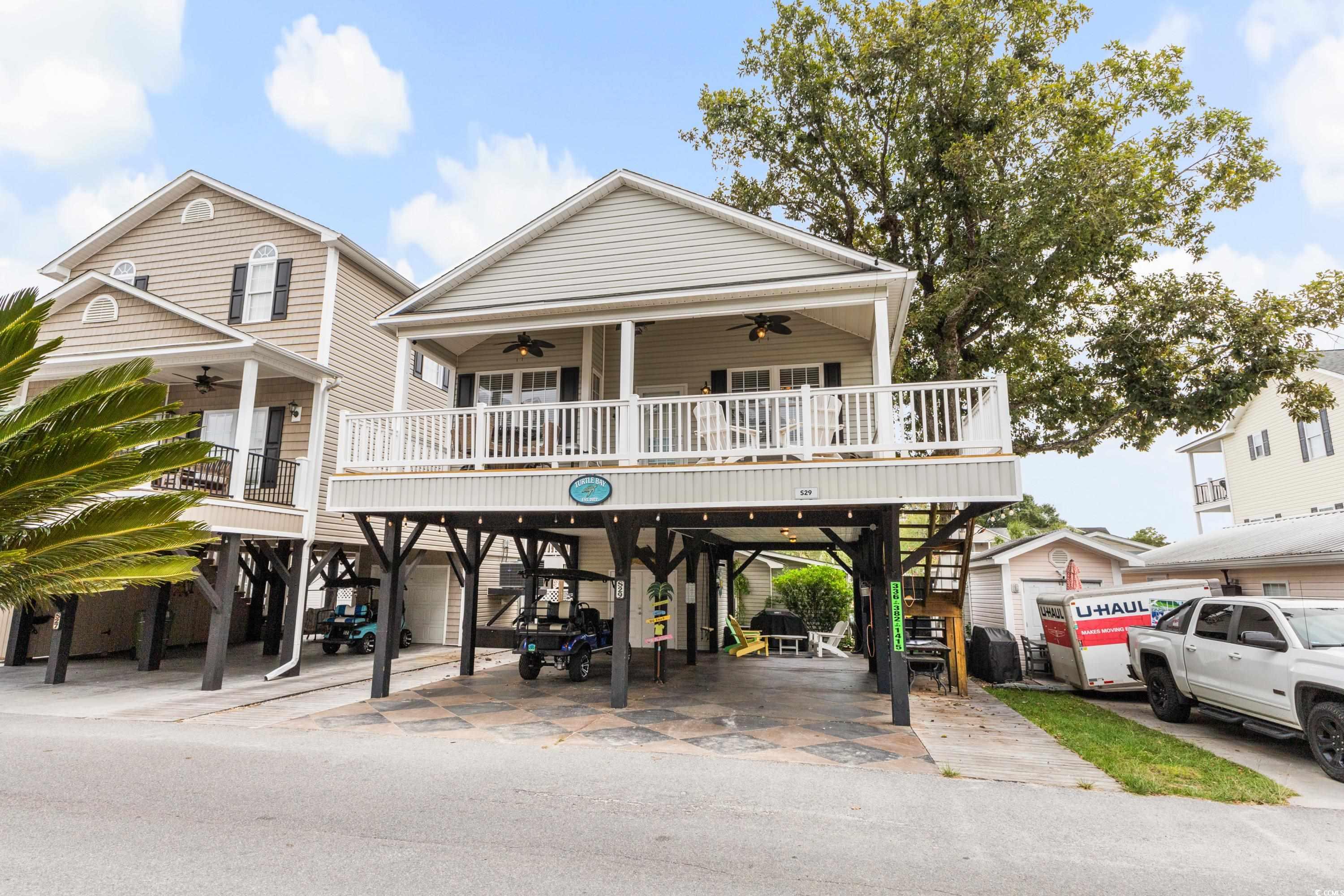 Exterior space with ceiling fan and a carport