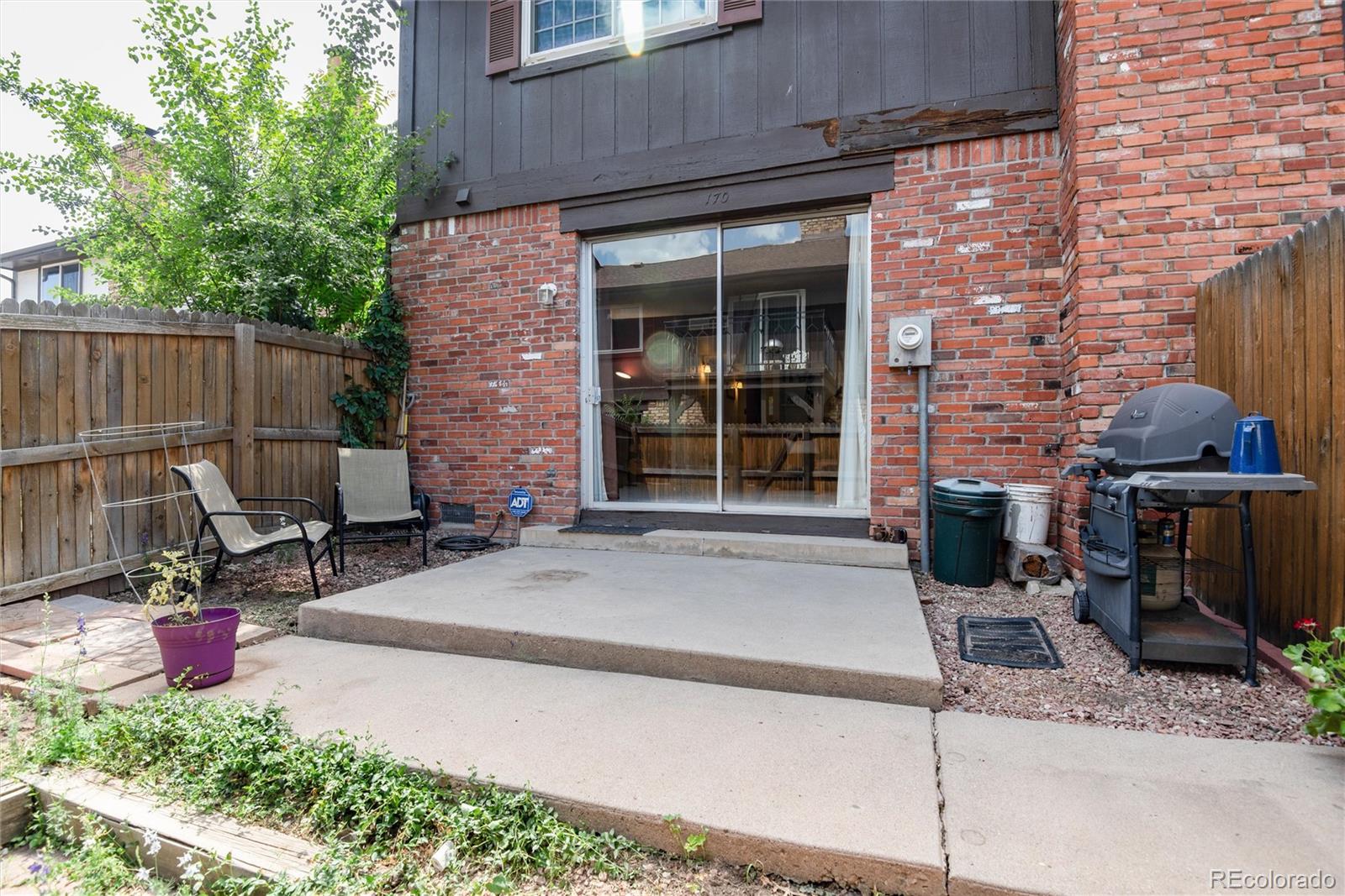 a view of a patio with table and chairs and potted plants