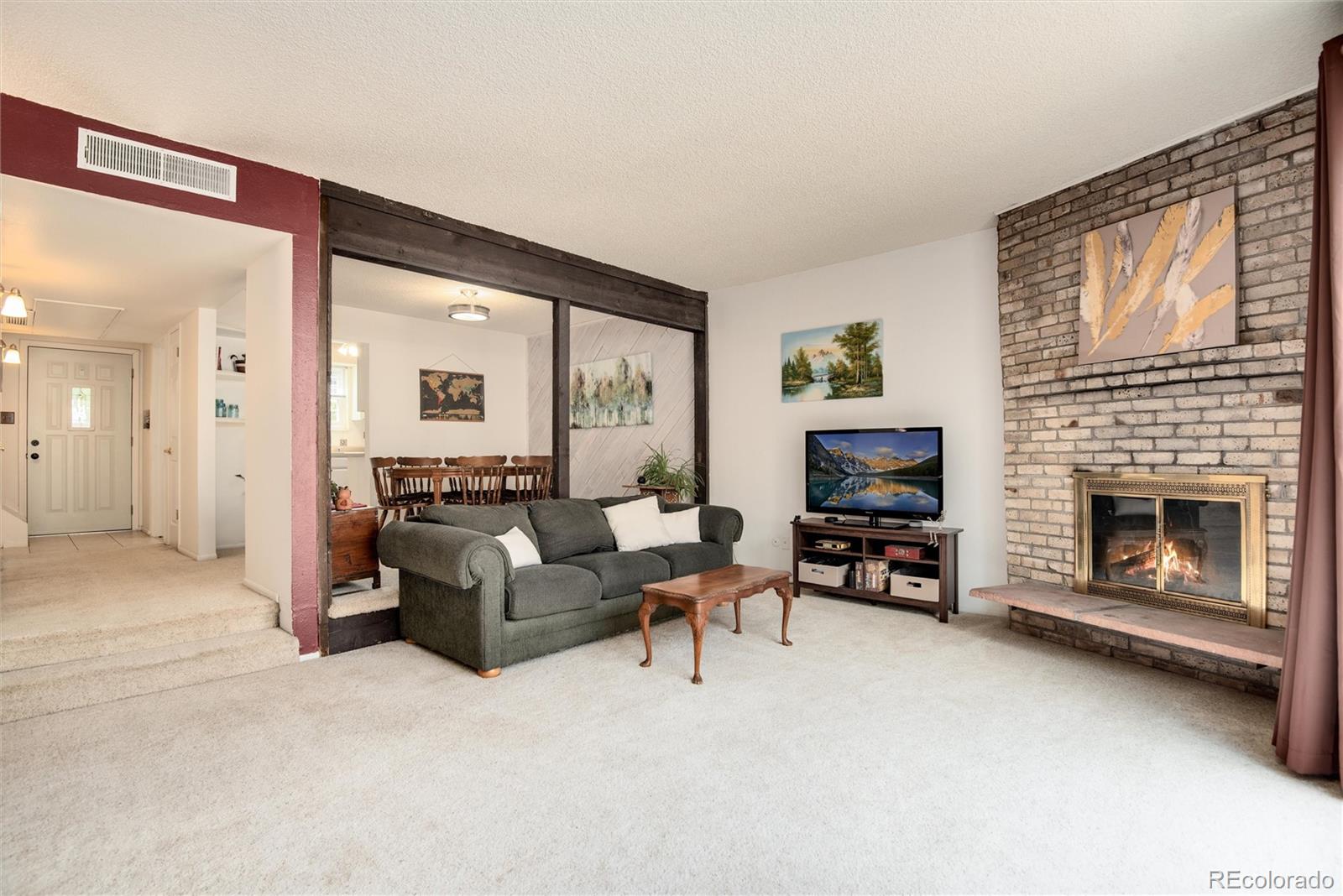 a living room with furniture a fireplace and a flat screen tv