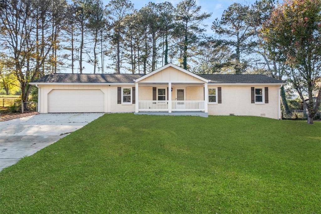 a front view of house with yard and trees all around