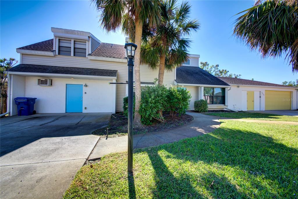 a front view of a house with a yard and palm tree