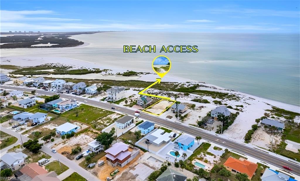 Birds eye view of property featuring a water view and a beach view