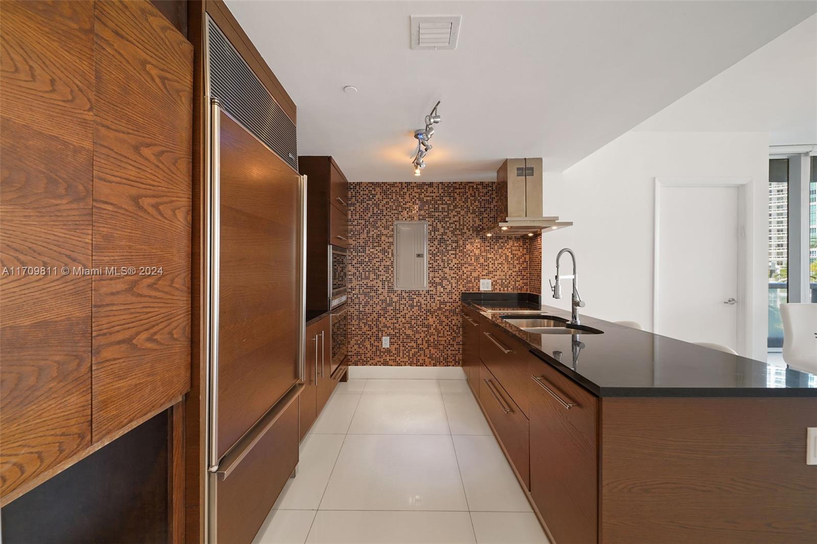 a large kitchen with granite countertop a sink and a stove top oven