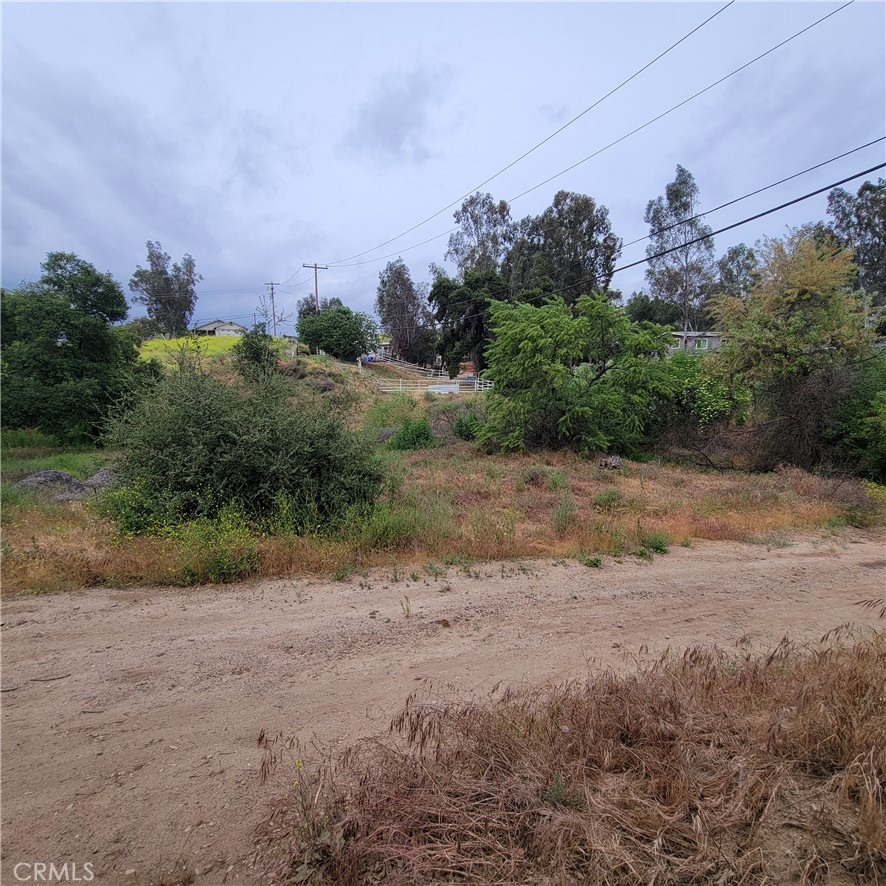 a view of a dirt road with a building in the background