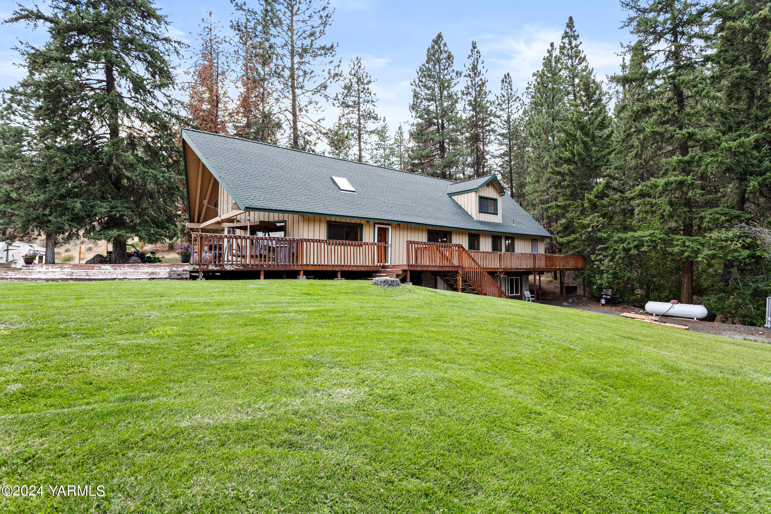 a aerial view of a house next to a big yard and large trees